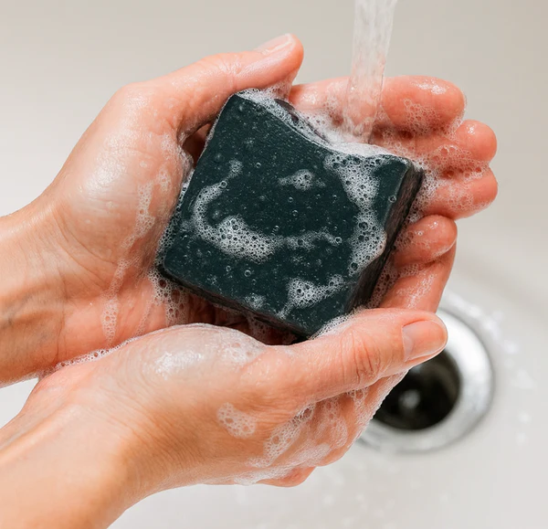 Pine Tar soap being rinsed in hands